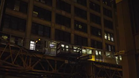 Night time exterior of loop train passing through elevated station on tracks  Stock Photos