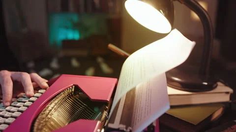 In the night time at home man using a old typewriter type some text on the white Stock Footage 135597298