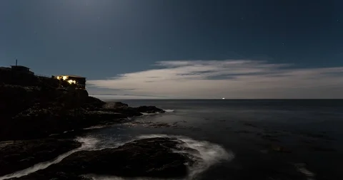 Night time lapse of a cliffside ocean view with a starry night sky and cirrus Stock Footage 119098719