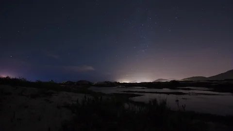 Night time lapse in a landscape with dunes and lakes, sky with stars. 4K Stock Footage 88969984