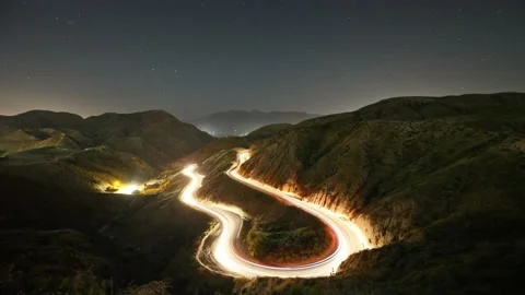Night time lapse of a road winding through the mountains Stockbeeldmateriaal 146256604