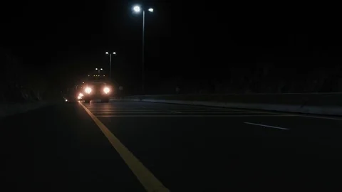 Night-time low angle shot of a group of military vehicles on a road Video stock 99500943