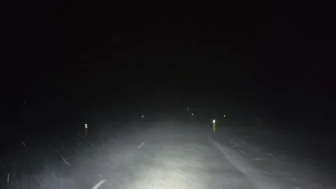 Night time shot of the road being blow with a winter storm Stock Footage 297246365
