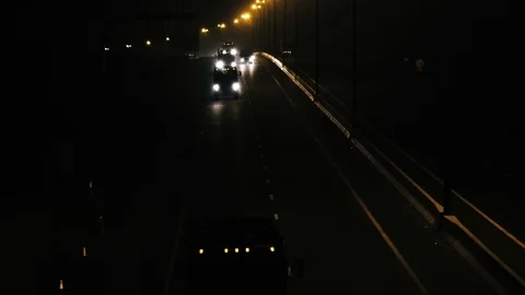 Night-time slow motion shot view of vehicles crossing a road Stock Footage 99500967