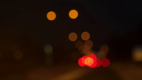 Night time soft focus bokeh shot of cars braking before red traffic lights Stock-Footage 100572383