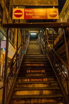 Night time view up dark outside staircase leading to elevated train station.  Stock Photos