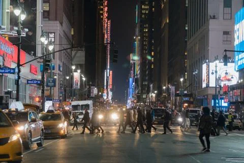 Night time wide angle view of midtown Manhattan NYC crosswalk during rush hour Stock Photos