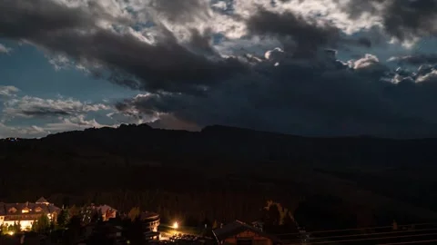 Night timelapse of clouds moving and sun rays emerging over Dolomites village Stock Footage 247638506