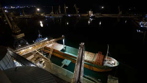 Night timelapse of loading grain crops on bulk freighter ship via trunk to open Stock Footage 90250023