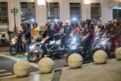 Night traffic at a city intersection with a row of motorbikes Stock Photos