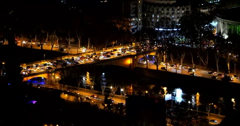 Night Traffic Crossing Illuminated Bridge Over River in Tbilisi Video stock 346336969