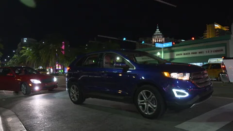 Night traffic driving through a busy intersection in South Beach Stock Footage 342563015