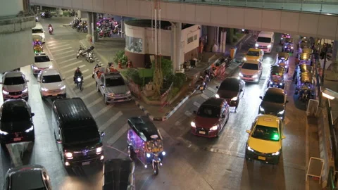 Night Traffic Flow at V-Shaped Junction with Tuk Tuks and Taxis Outside MBK Cent Stock Footage 328790871