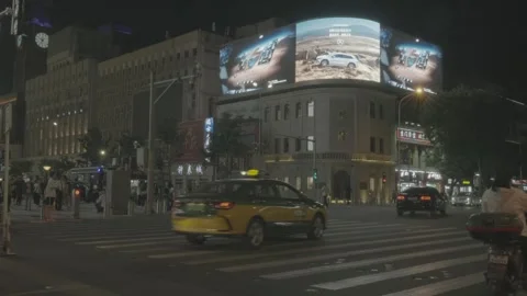 Night Traffic Passes Beneath Digital Billboard in Wangfujing Beijing 스톡 동영상 340481525