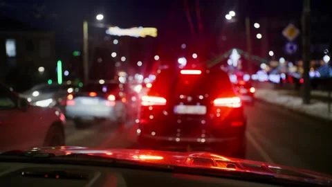 Night traffic view from car interior on city street with blurred city light.. 库存影片 335347265