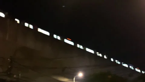 Night train passing through over traffic road 4k handheld footage Stock Footage 284362087