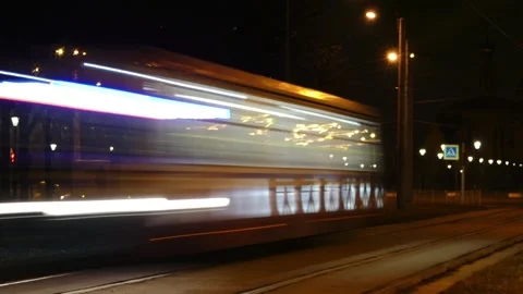 Night tram passing by leaves a light trail, time lapse Stock Footage 303658747