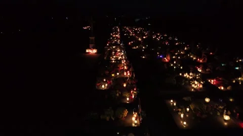 A night view from above of a cemetery lit by candles and lanterns on the graves Stock Footage 332410728