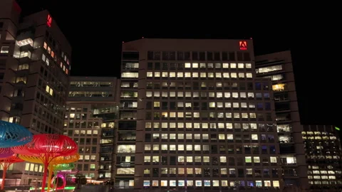 Night view of Adobe headquarters in San José with illuminated windows and city Video stock 301869900