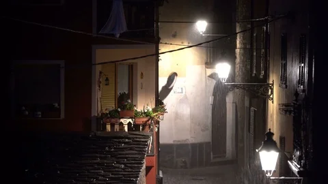 A night view of an ancient road between the houses during a strong summer storm Stock Footage 112617318