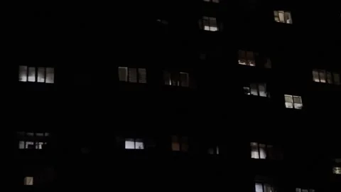 Night view on apartment building with illuminated windows. Warm lights glow from Stock Footage 340349972