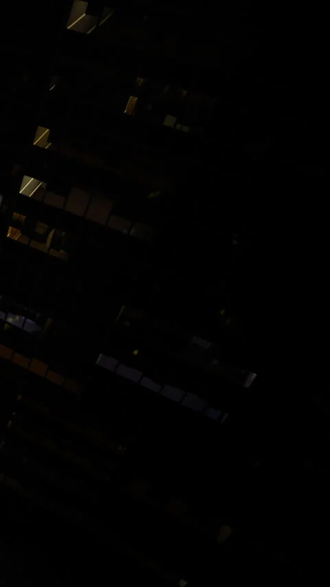 Night view of buildings with lights on in different windows Stock Footage 334723891