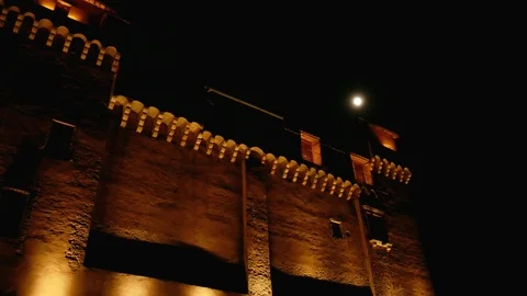 Night view of a castle with light beam and the moon - Pan Stock Footage 90294593