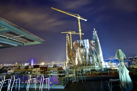 Night View of Cathedral Under Construction with City Skyline Stock Photos