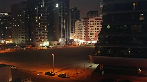 Night view of a city lot surrounded by illuminated high-rise buildings Stock-Footage 335501994