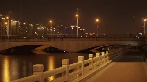 Night View of Concrete Bridge Over River with City Lights Vidéo 334638765