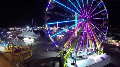Night view of a fair grounds and a spinning ride Stock Footage 47709213