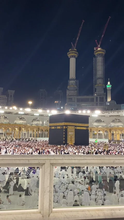 Night View of the Holy Kaaba and Masjid al-Haram with Pilgrims and Construction Stock Footage 323159164