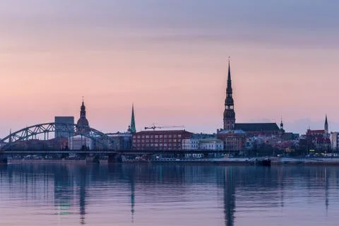 Night view on the illuminated riverside with reflection on the river in Riga Stock Photos