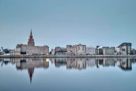 Night view on the illuminated riverside with reflection on the river in Riga Foto stock