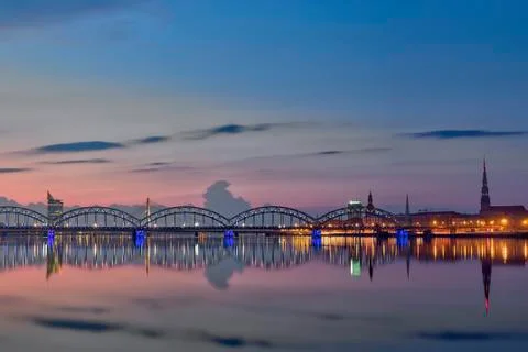 Night view on the illuminated riverside with reflection on the river in Riga Stock Photos