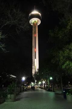 Night view of illuminated tower surrounded by trees and a peaceful walkway Stock Photos