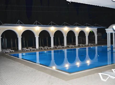 Night view of the luxurious pool with columns and arches, reflected in the wa Stock Photos