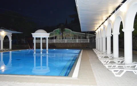 Night view of the luxurious pool with columns and arches, reflected in the wa Foto stock