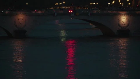 Night view of a Paris bridge with glowing streetlights and colorful reflections Stock Footage 314033397