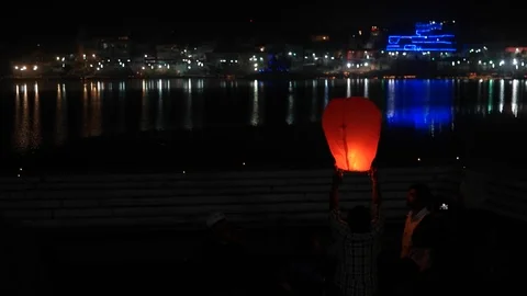 Night view of people lighting lighting paper lamps Pushkar Lake Stock Footage 99763248