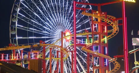 Night view of a roller coaster in front of the Ferris Wheel of Prater, Vienna, Stock Footage 252022630