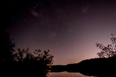 Night view of the starry sky on the lake with a bonfire on nature in summer Stock Photos