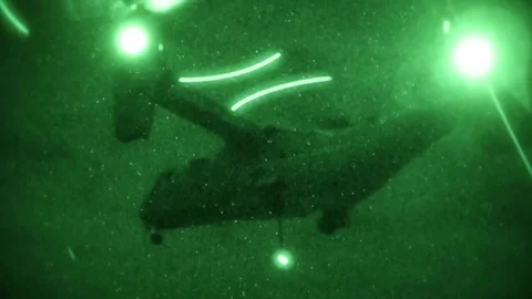 Night vision imagery of MV-22 Osprey hovering with sling load Stock-Footage 101376428