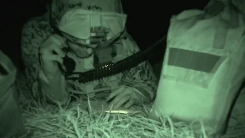 Night vision imagery of soldier talking on radio while reading from notebook Vidéo 85227366