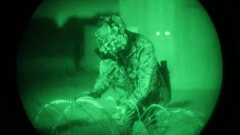 Night vision imagery of U.S. Marines unraveling concertina razor wire Stock Footage 295113170