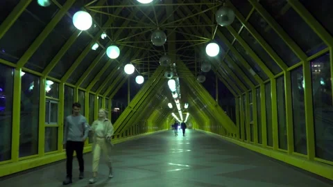 Night walk on the modern covered pedestrian bridge over the river Stock Footage 161036853