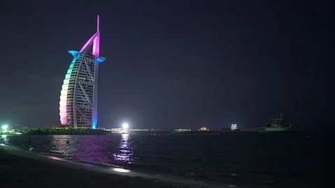 Nightly Dubai, beach washed by the waves. Burj Al Arab in the night, moonlight Stock Footage 106287079