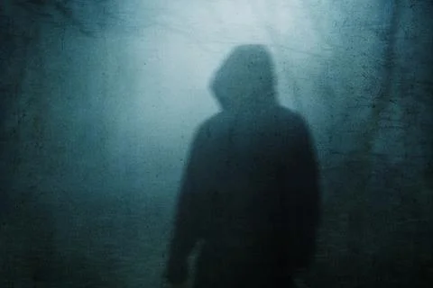 A nightmare concept of a hooded figure on a path through a spooky forest Stock Illustration
