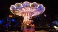 Nightshot colorful chain carousel in action with happy people 4k or 4k+ Resolution