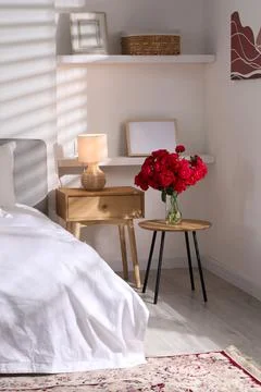 Nightstand, lamp and decorative elements in bedroom. Interior design Stock Photos